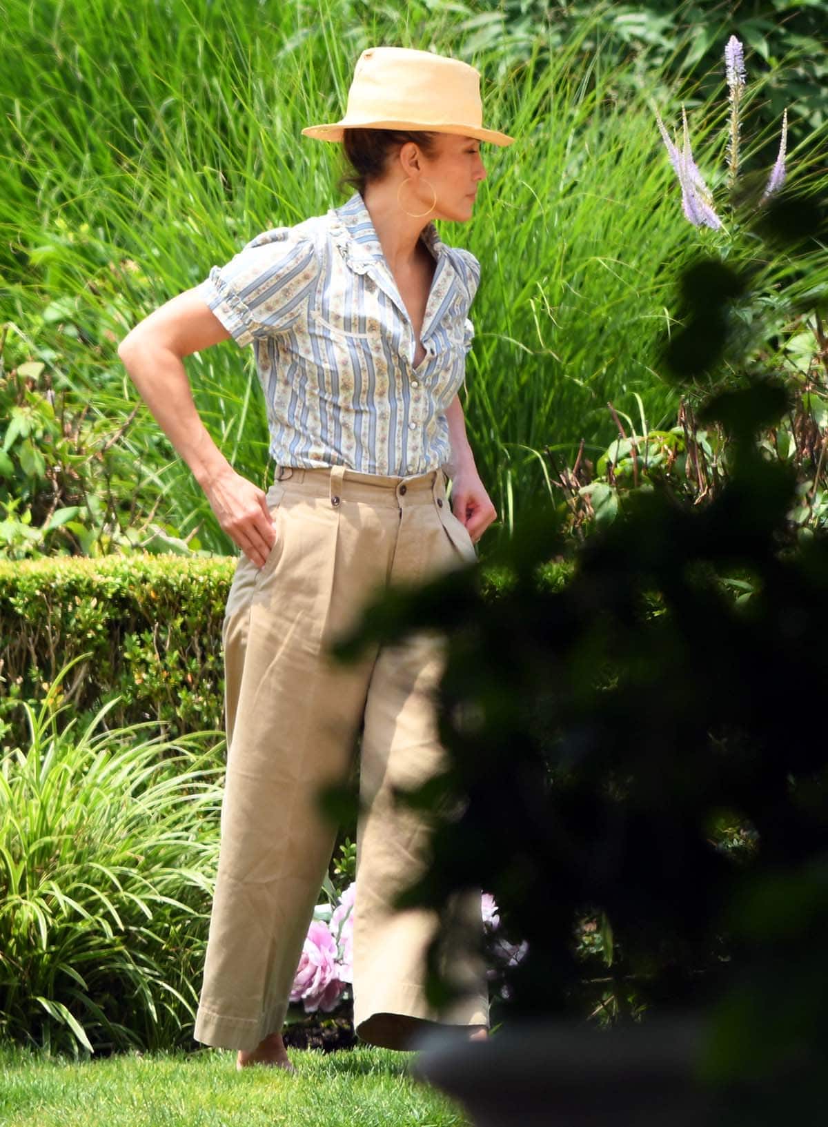 Jennifer Lopez embraces countryside summer chic in a striped cotton blouse with antique motifs and a pair of khaki wide-leg pants