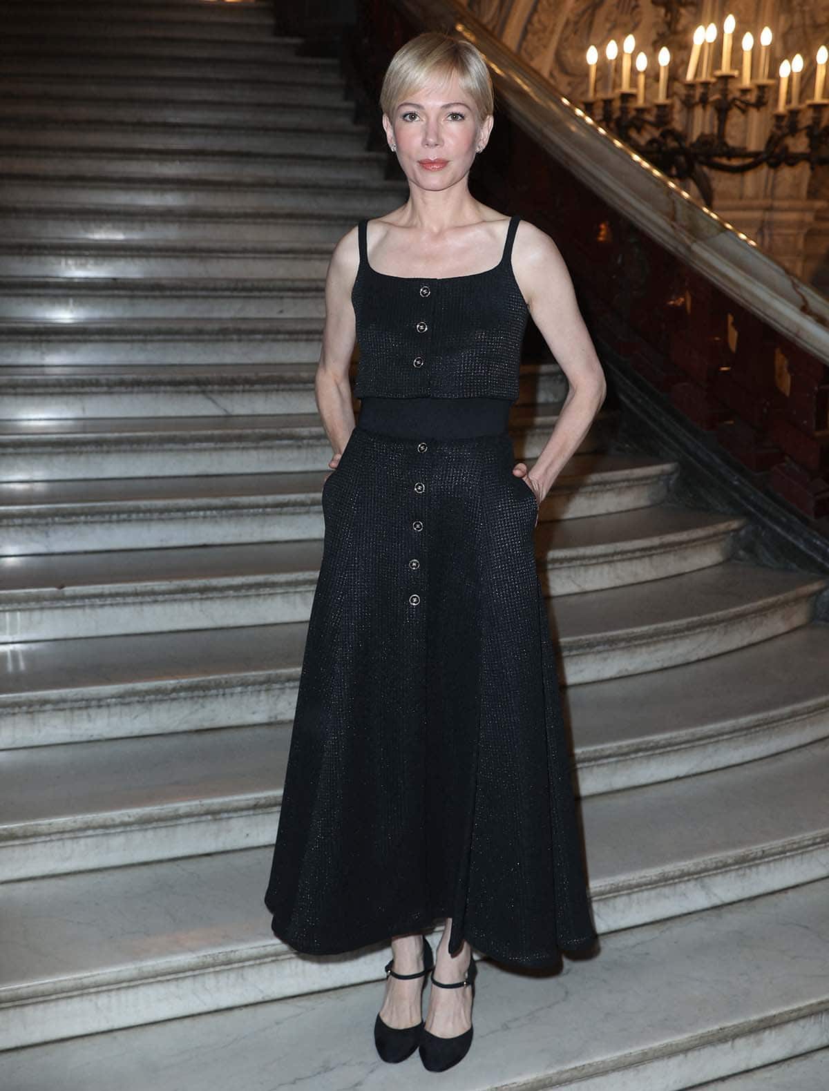 Michelle Williams dons a simple but elegant black Chanel dress with reflective silver lurex and logo-emblazoned buttons at the Chanel Paris Fashion Week Haute Couture Fall/Winter 2024-2025 show