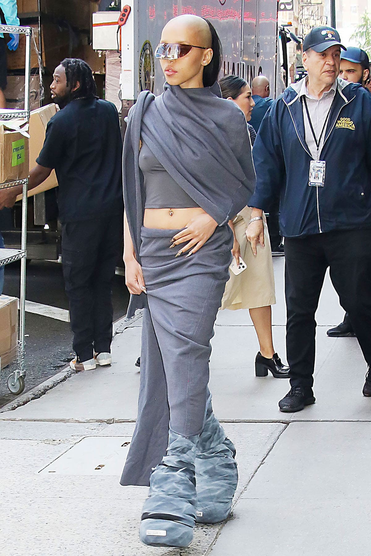 FKA Twigs goes for a dystopian look, wearing an asymmetric gray crop top with a midi skirt by Rombaut as she exits the GMA studios