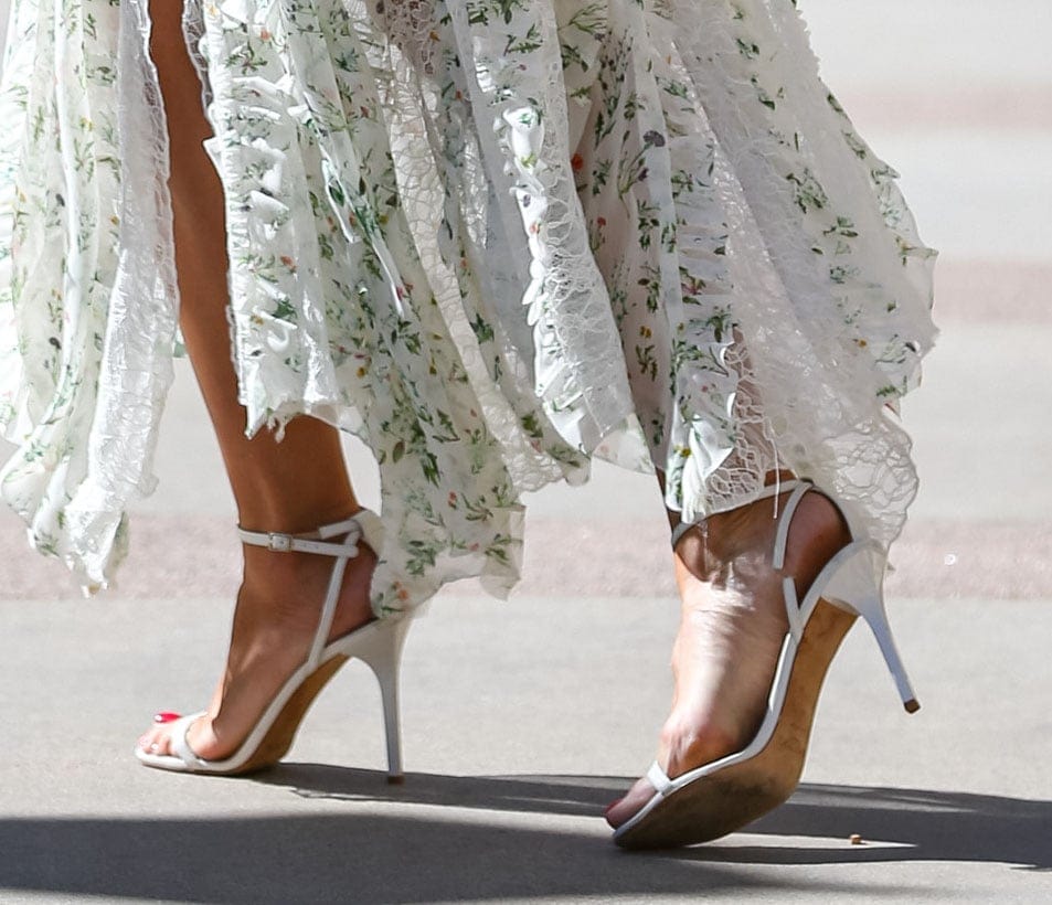 Heidi Klum completes her summertime look with white open-toe sandals, showcasing her red pedicure