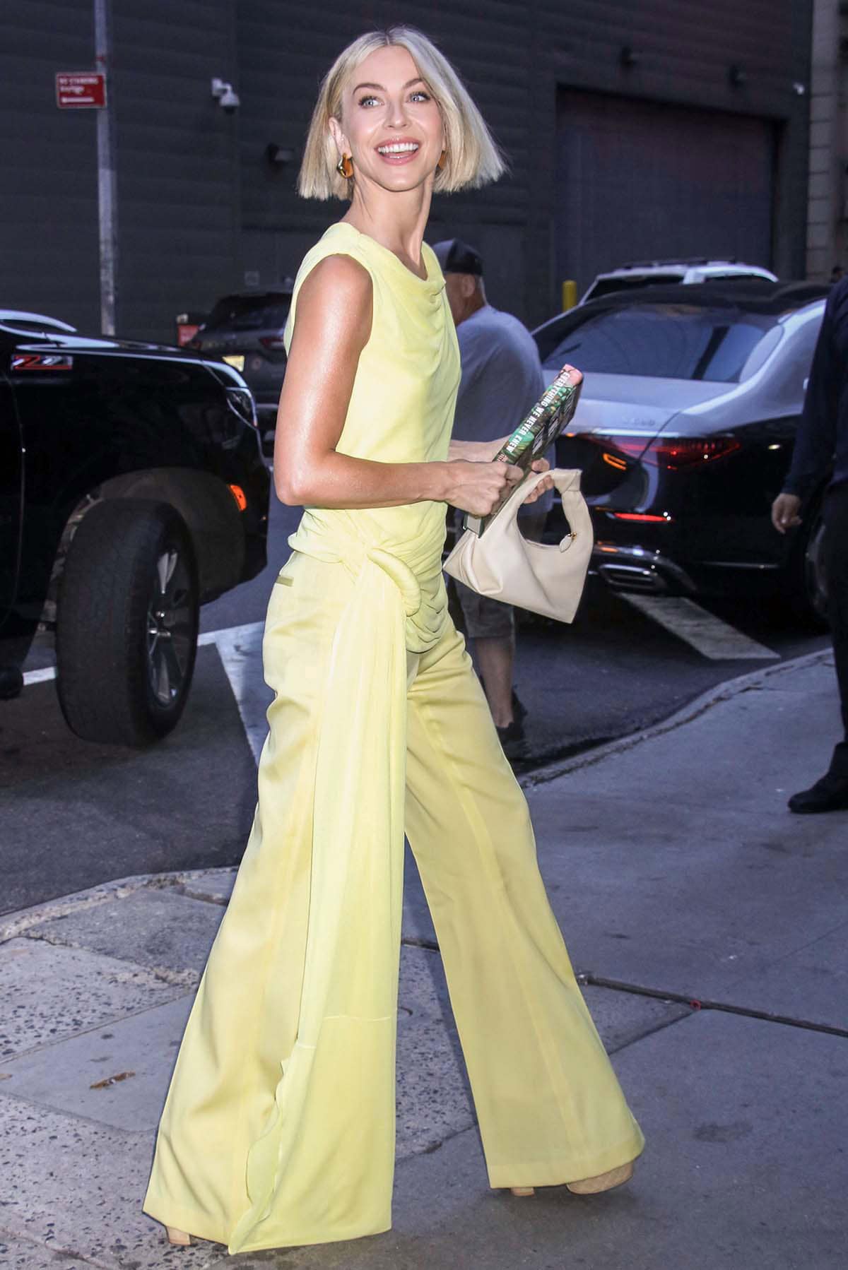 Julianne Hough looks radiant in a yellow Del Core ensemble featuring a draped sleeveless top and flared pants for her appearance on Good Morning America