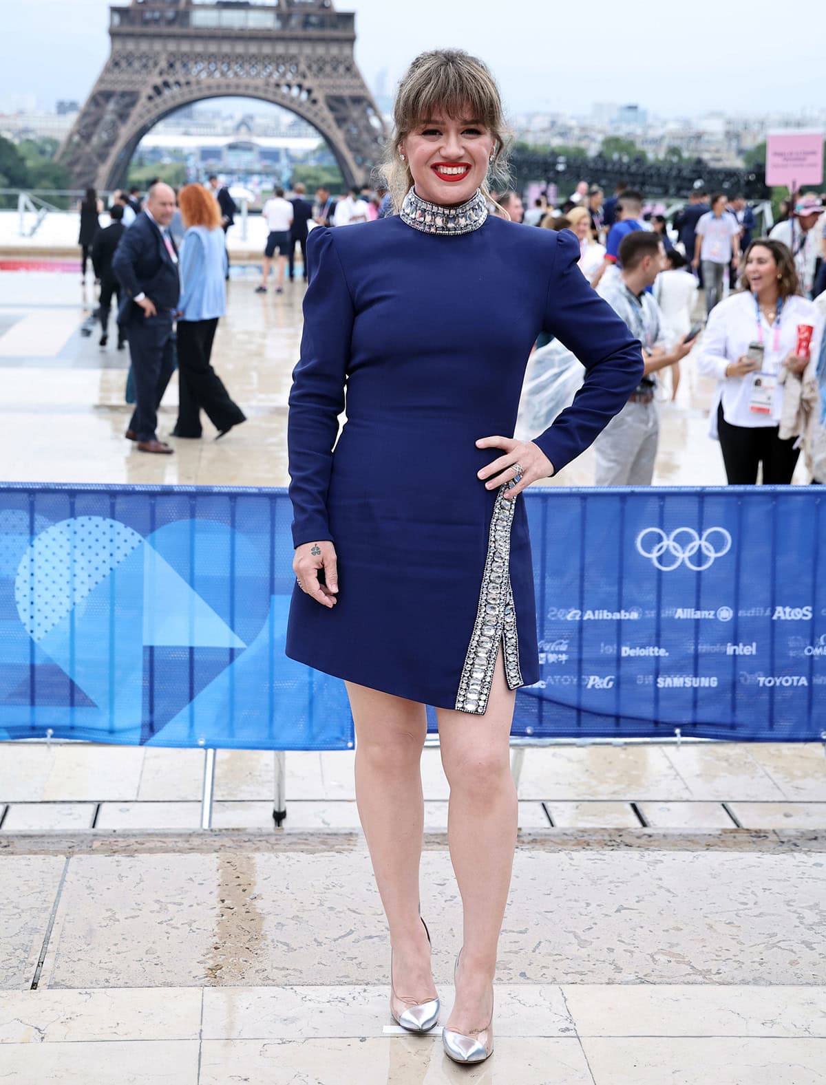 Kelly Clarkson arrives at the 2024 Paris Olympics opening ceremony wearing a blue Andrew GN mini dress with chunky crystal accents around the neck and daring slit