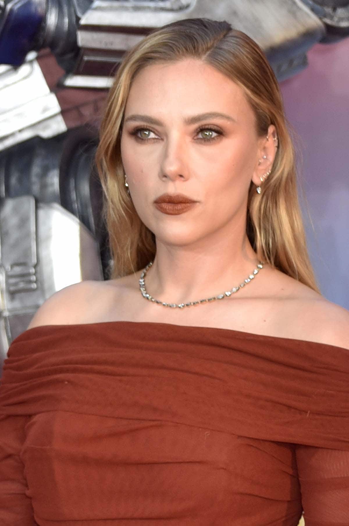 Scarlett Johansson matches her glam with her dress, wearing smokey reddish-brown eyeshadow and matte red lipstick