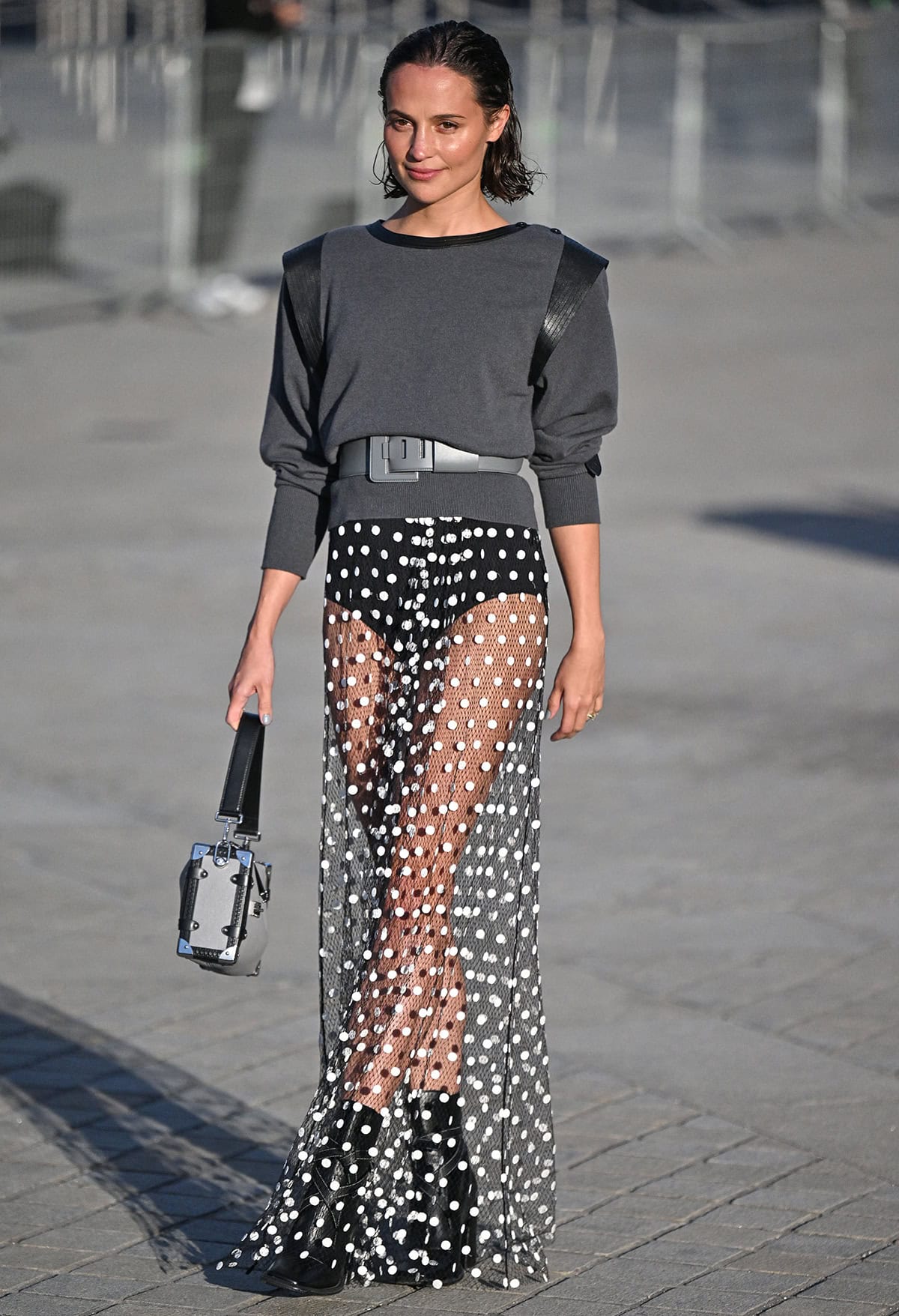 Alicia Vikander shows off her toned legs in a polka-dot mesh maxi skirt with a leather-trimmed charcoal sweater