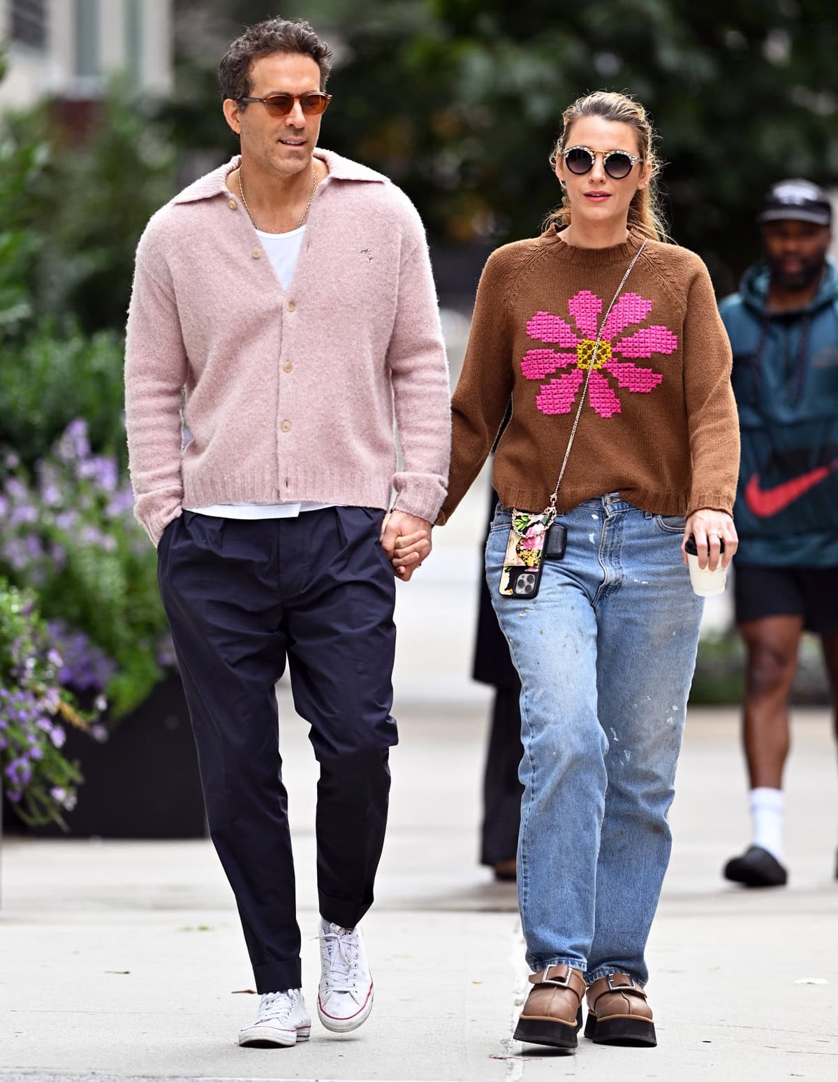 Blake Lively steps out in NYC on September 23, 2024, holding hands with Ryan Reynolds while sporting a playful Farella Baba Flower Sweater, relaxed jeans, UGG x Opening Ceremony Tasman slippers in Chestnut, and a chic Bandolier Hailey Floral Crossbody