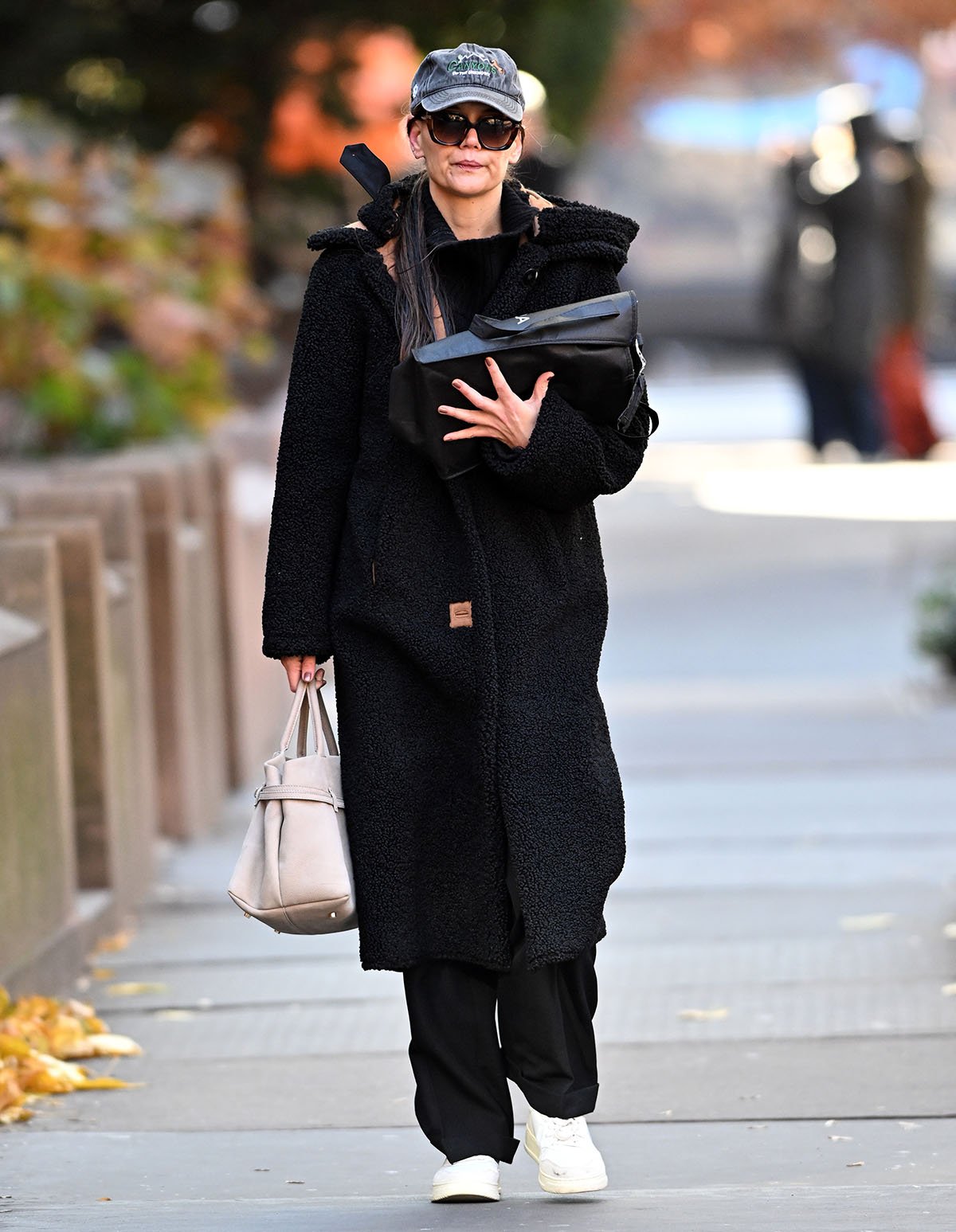 Katie Holmes stays cozy in a black Stand Studio faux fur coat, paired with relaxed trousers and sneakers, as she heads to her Broadway play on November 30, 2024