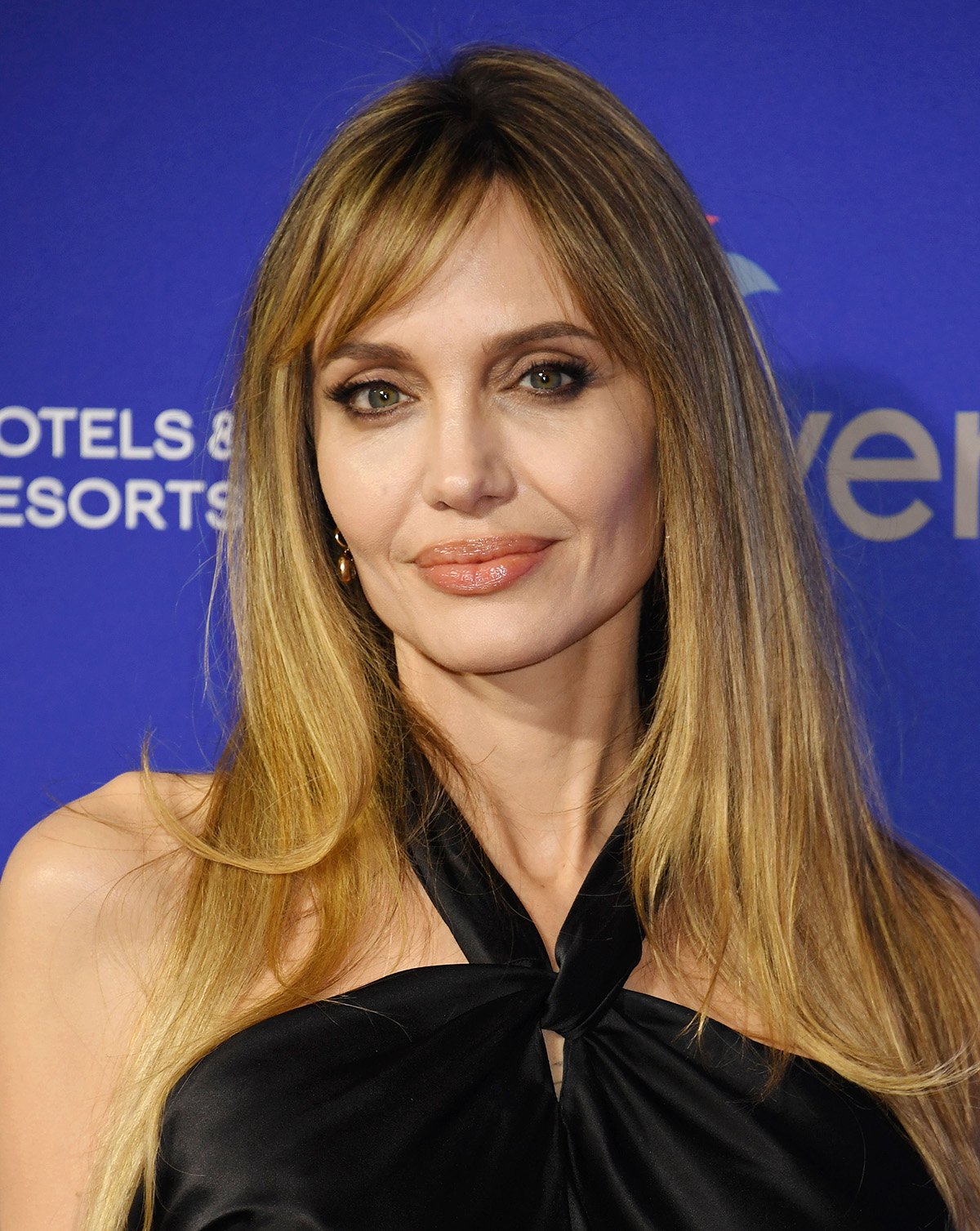 Angelina Jolie debuts a new hairstyle, letting her layered honey-blonde tresses fall loose around her shoulders with side-swept bangs giving her a youthful look