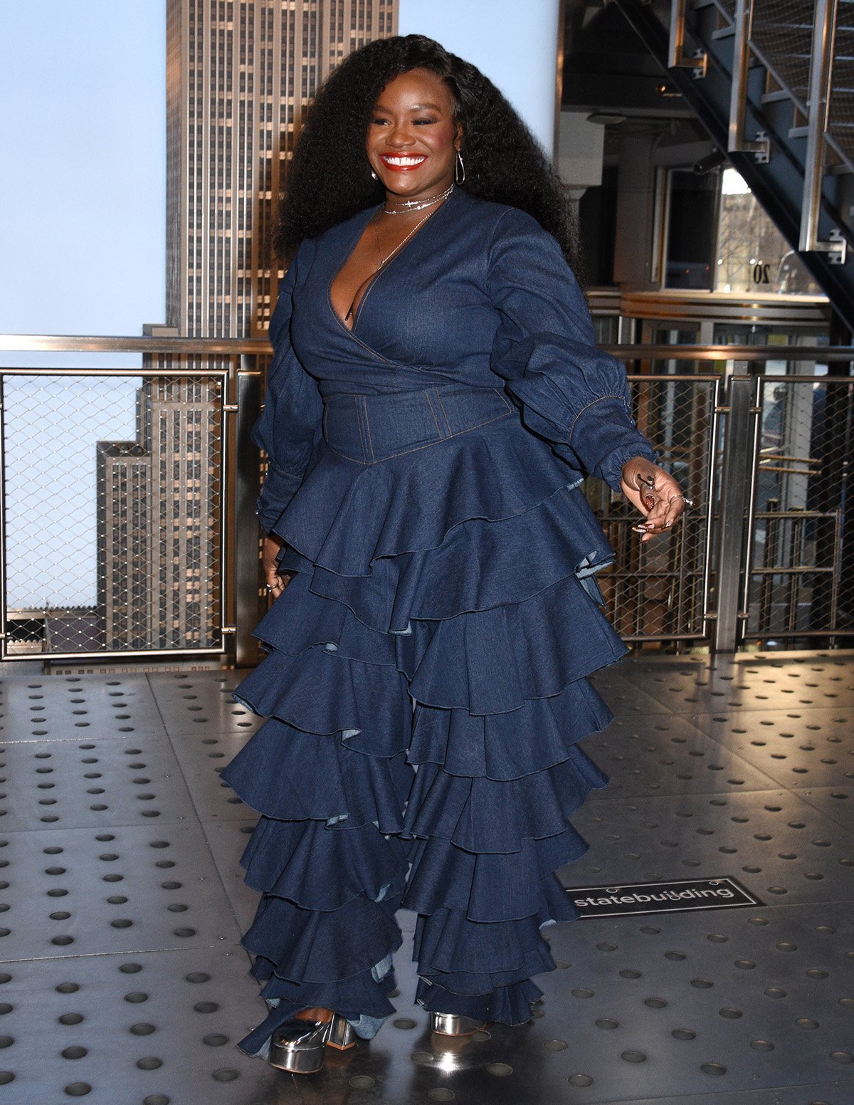 Shoniqua Shandai shows her take on Canadian Tuxedo by wearing a denim wrap top and tiered ruffle high-waist denim pants