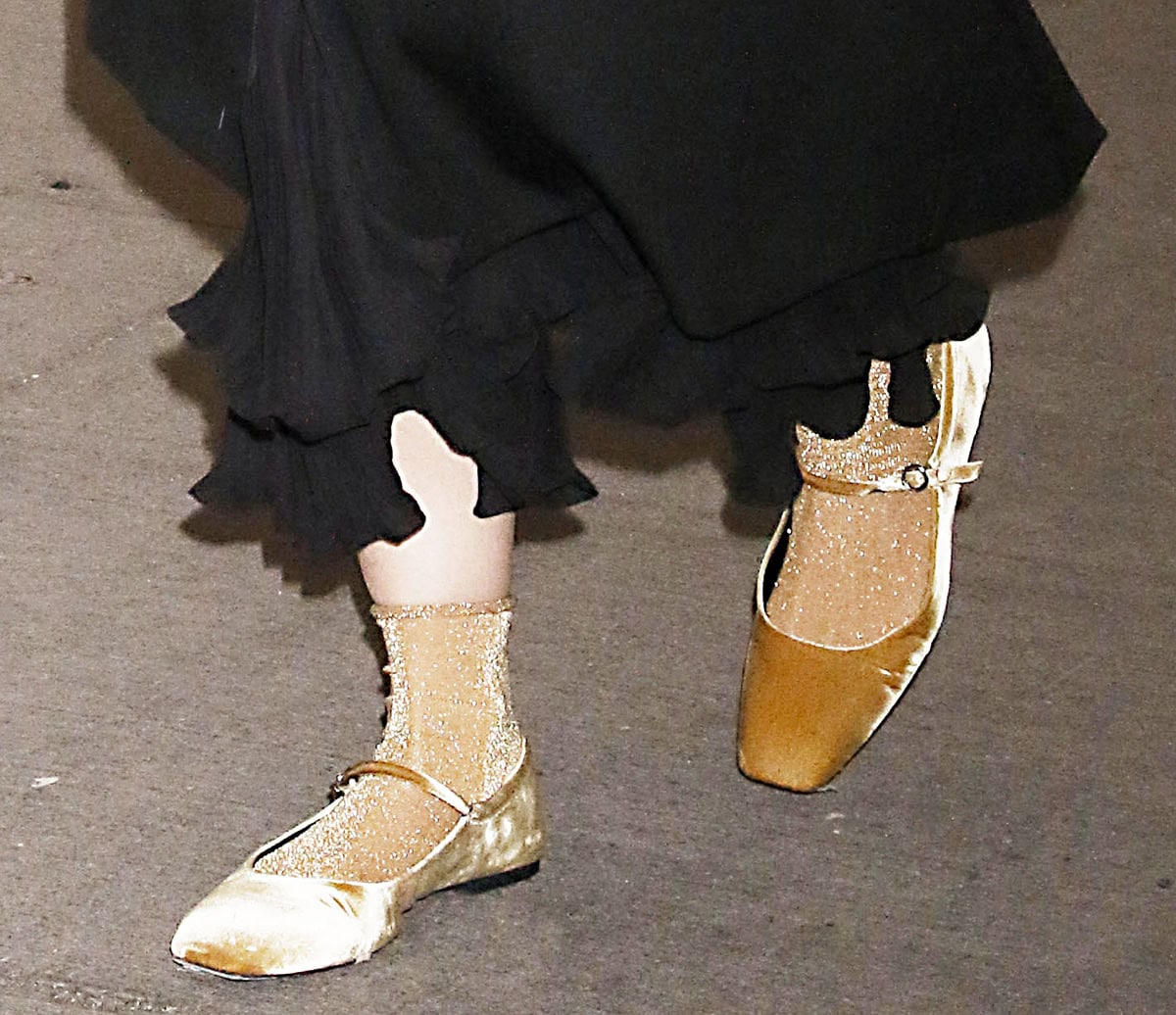 Katie Holmes completes her preppy-edgy look with gold Lurex socks and gold velvet Mary Jane flats