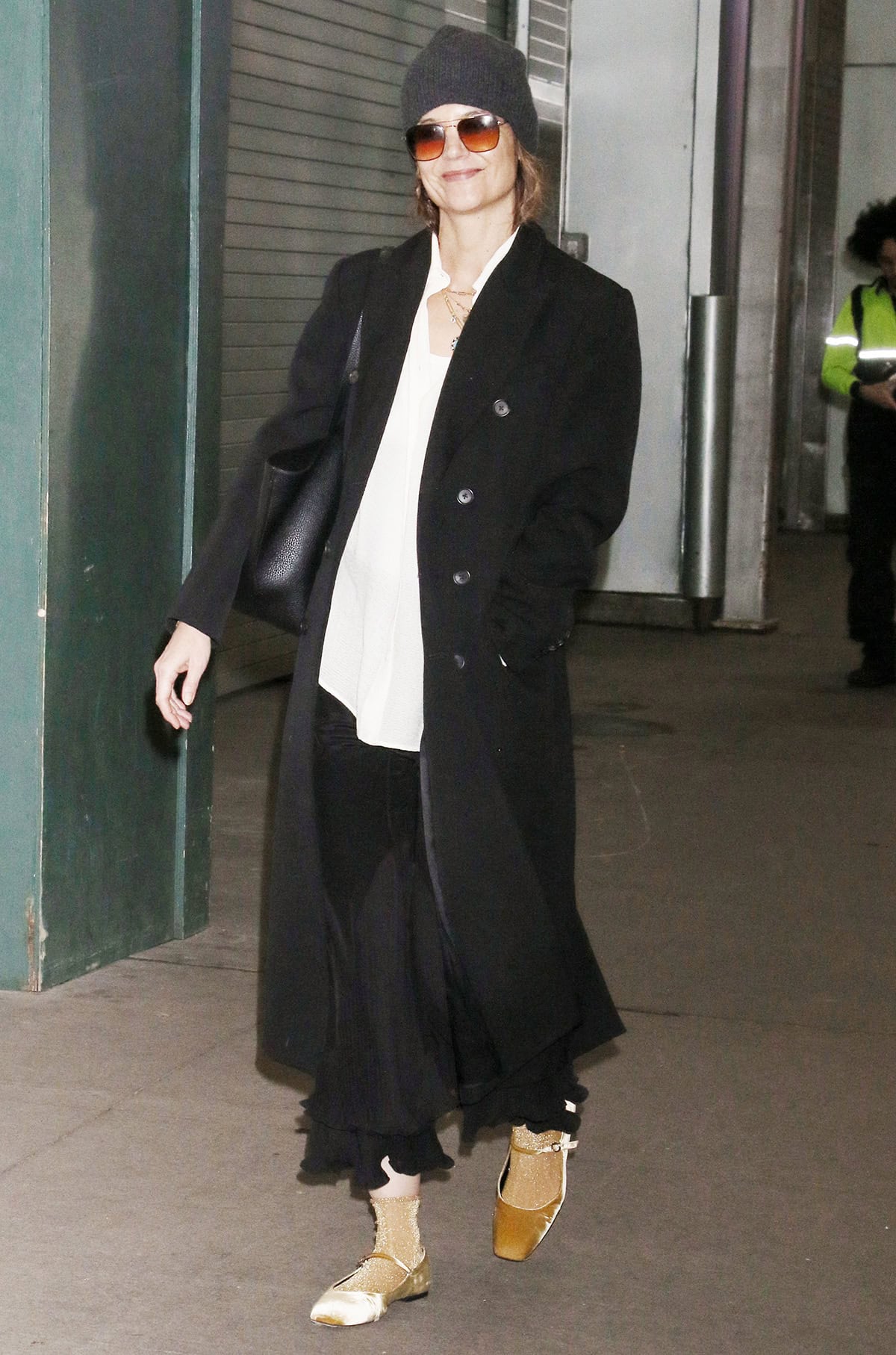 Katie Holmes shows off her unique fashion sense, wearing a white shirt, a black skirt, and gold flats on her way to the Barrymore Theatre for the Broadway production of Our Town