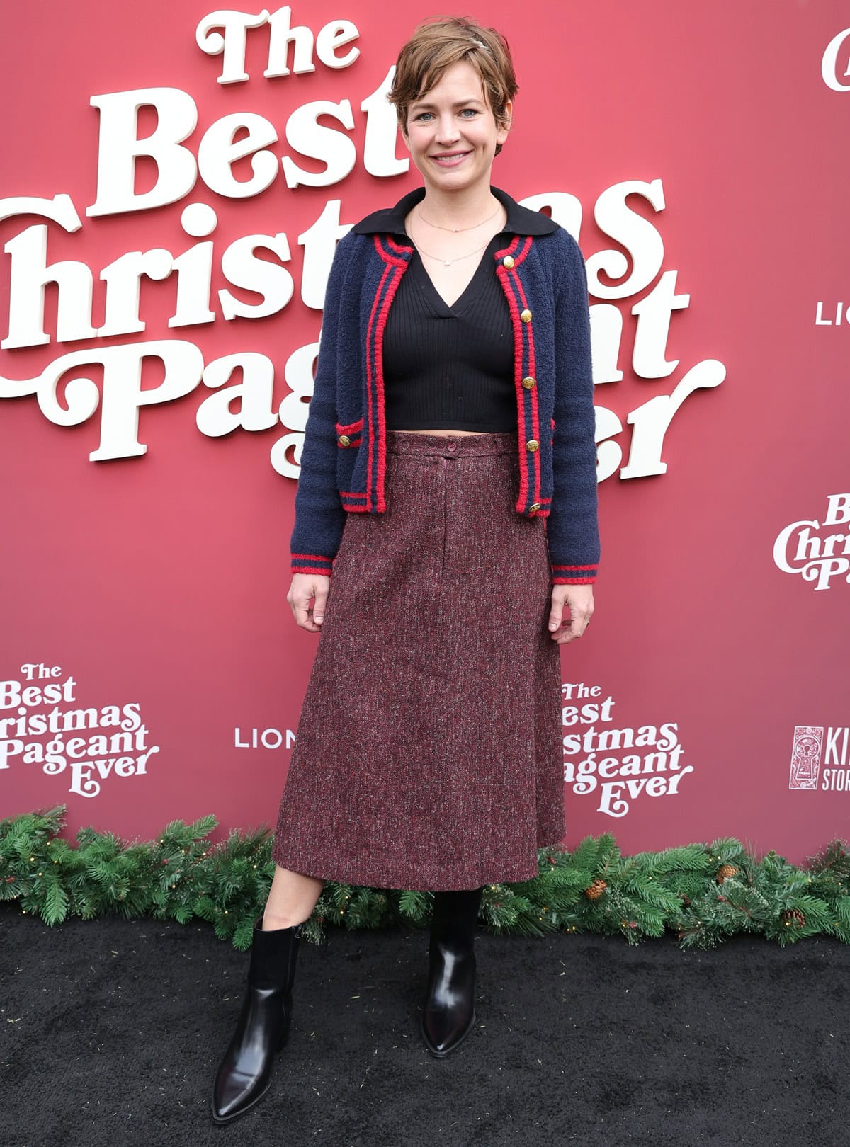 Britt Robertson exudes cozy sophistication at The Best Christmas Pageant Ever Los Angeles premiere on November 2, 2024, pairing sleek black booties with a textured midi skirt, a cropped knit cardigan, and a chic V-neck top for a polished yet festive look