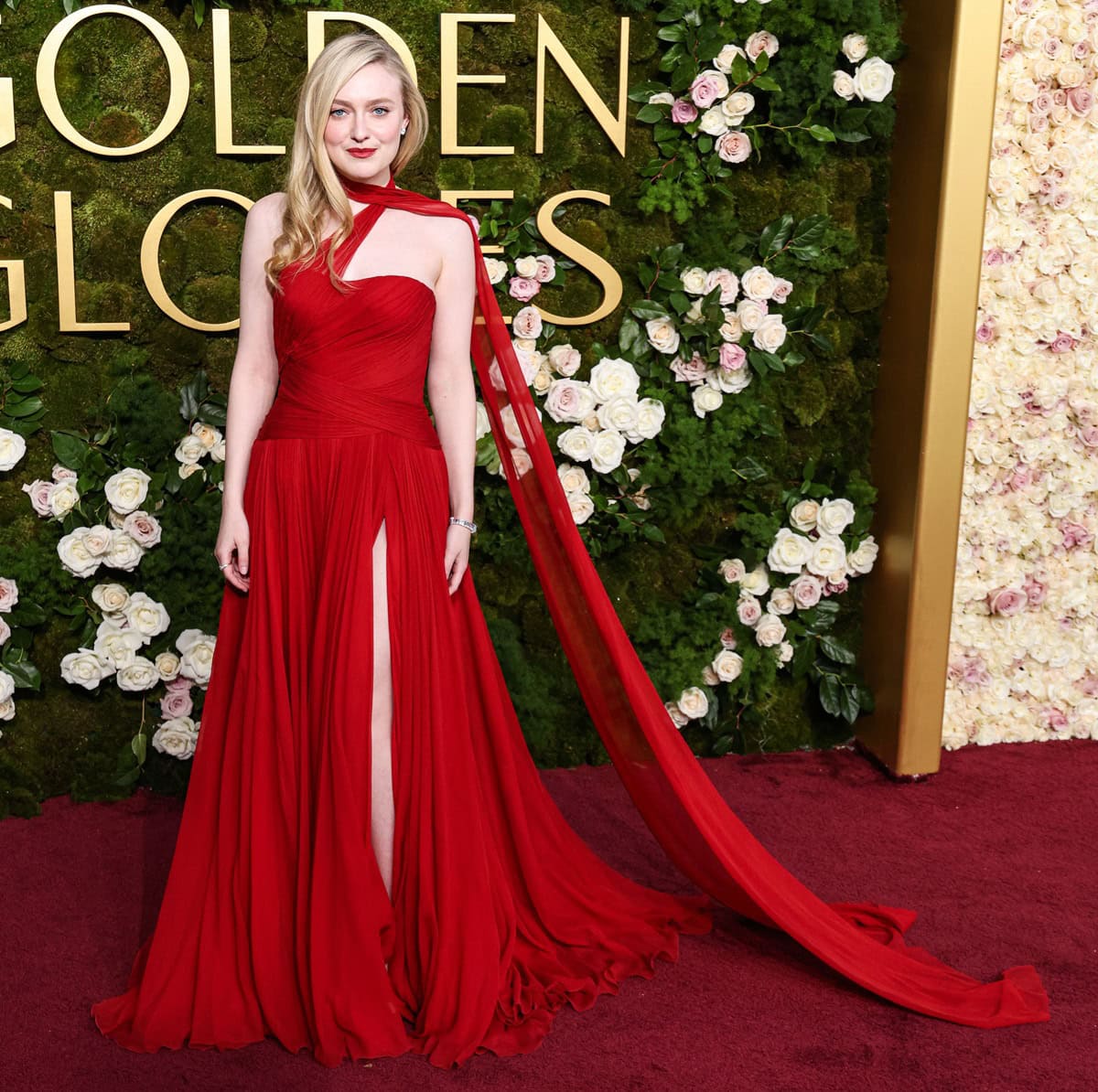 Dakota Fanning exuded elegance at the 2025 Golden Globe Awards in a striking Dolce & Gabbana custom red gown with a flowing cape and thigh-high slit—though her choice of shoes remained hidden beneath the sweeping fabric