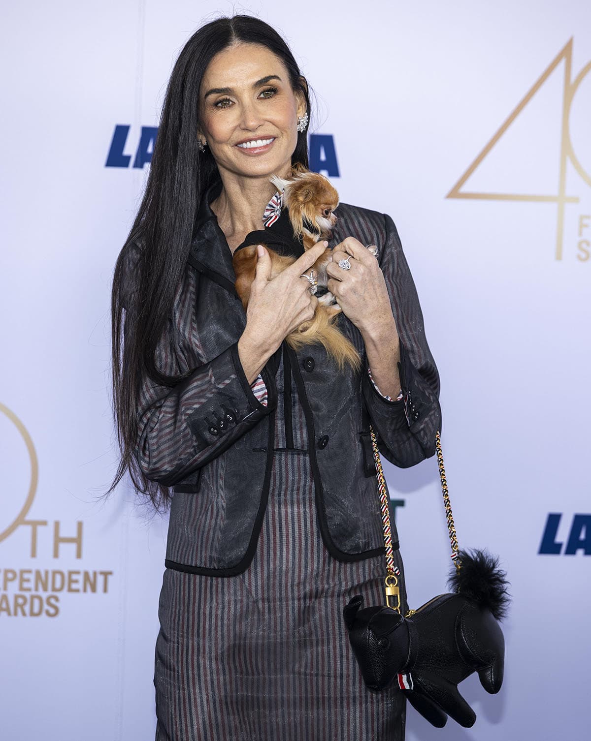 Demi Moore carries her essentials in Thom Browne's rabbit bag with a fur tail as she cradles her adorable pup Pilaf