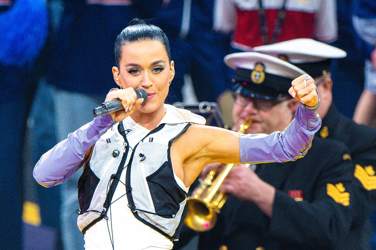 Katy Perry elevates her sporty ensemble with a sleek high ponytail, earrings, and a full face of makeup