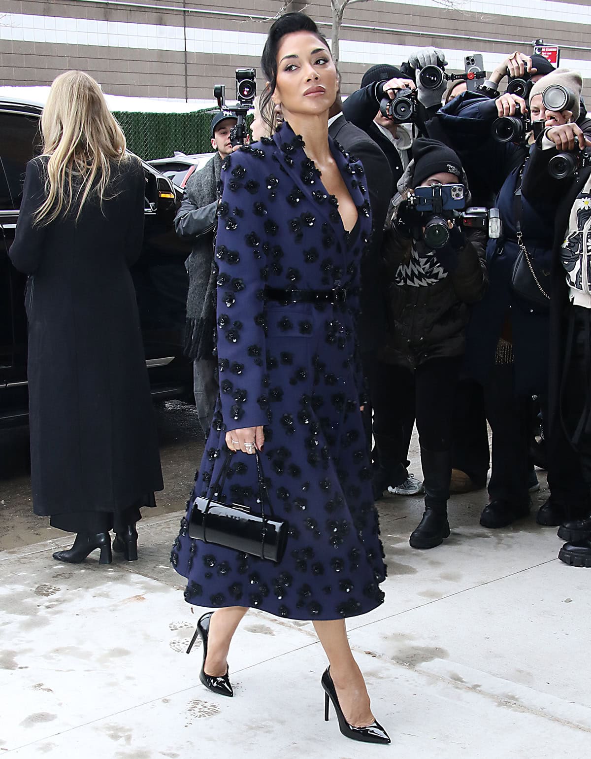 Nicole Scherzinger is hard to ignore in her deep purple coat dress with 3D sequin florals and a waist-cinching belt