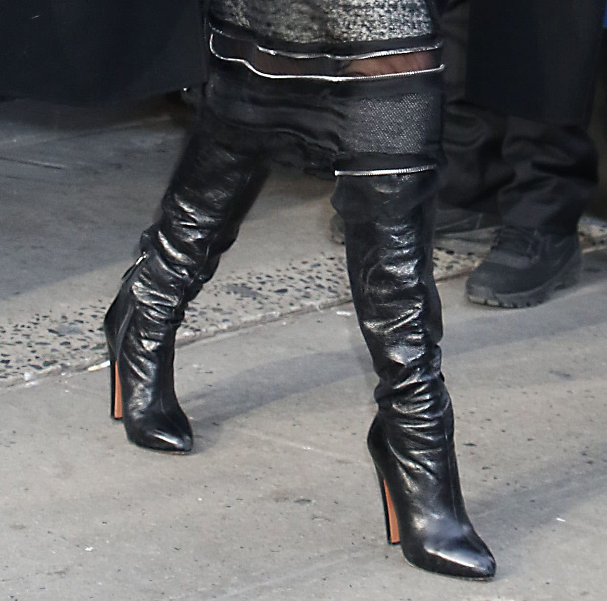 Tamron Hall looks edgy and confident in black leather boots by Alaïa featuring slouchy knee-high shafts, almond toes, and block heels