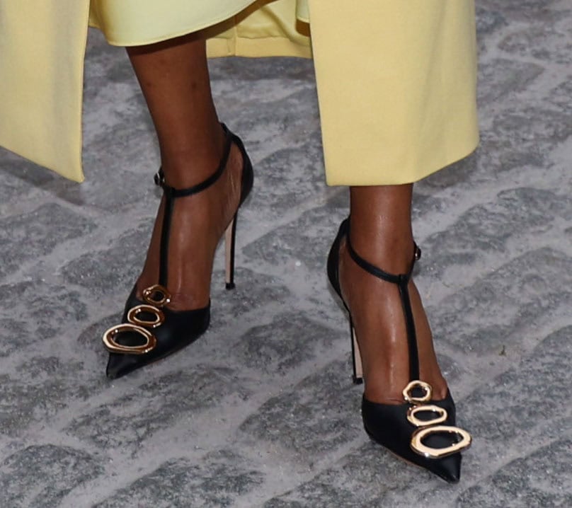 Tiffany Haddish pairs her yellow slip dress with black T-bar pumps featuring gold-tone accents at the toes