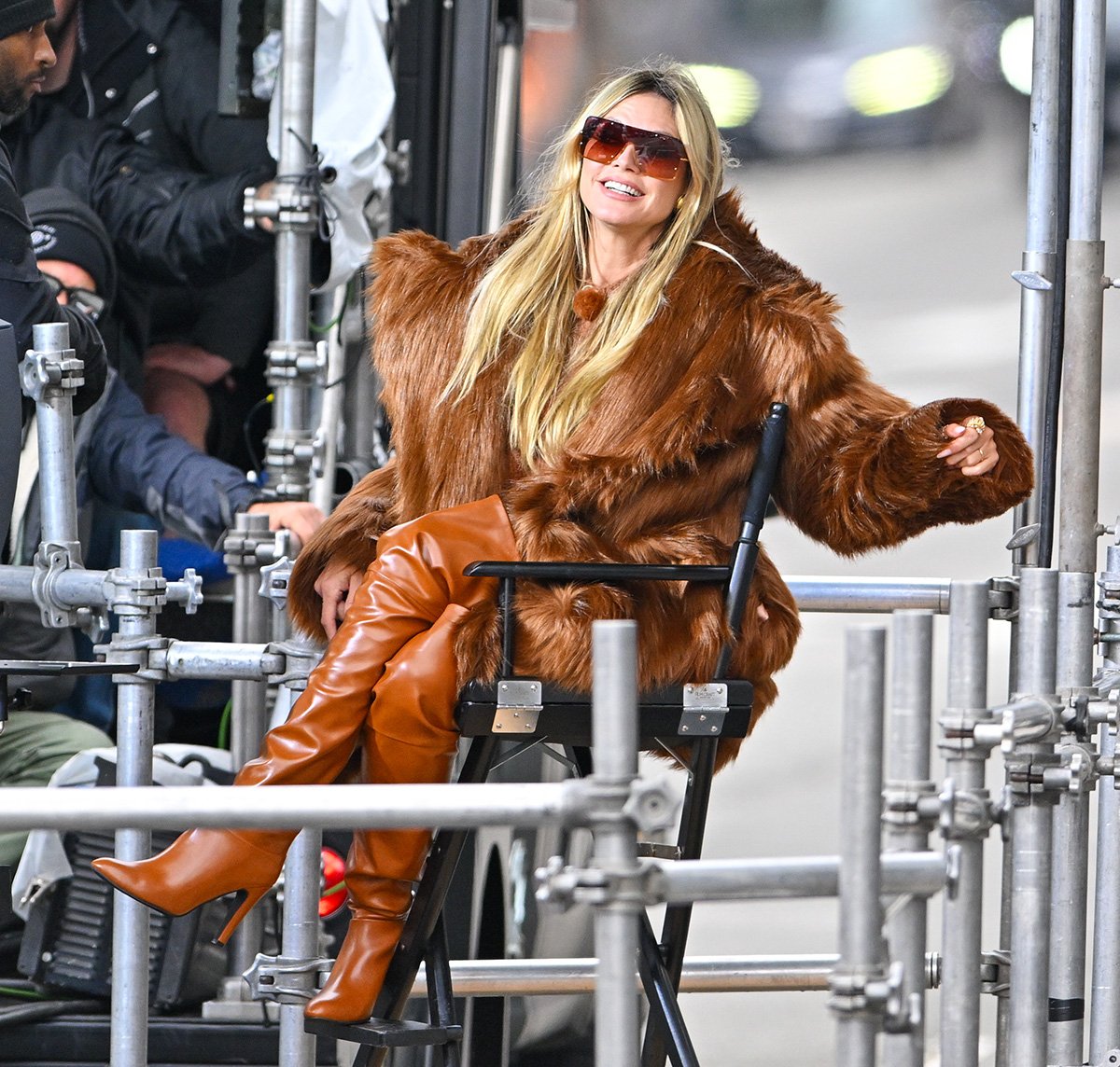 Heidi Klum teams her brown boots with a cozy brown furry coat and a brown knit sweater underneath