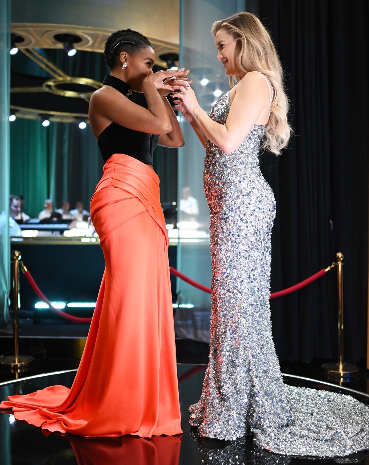 Janelle Monáe stuns in a bold black-and-orange Vera Wang ensemble alongside the statuesque Kate Hudson in a shimmering silver gown, highlighting their striking height contrast