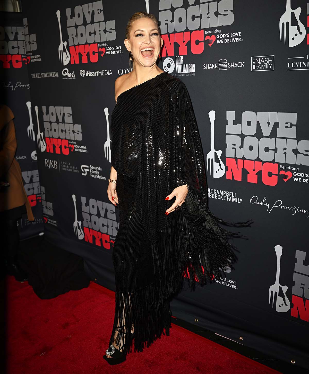 Kate Hudson shimmers in a black one-shoulder sequin-embellished top and matching column skirt with fringe trims